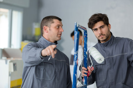 painting apprentice holding a roller brushの写真素材