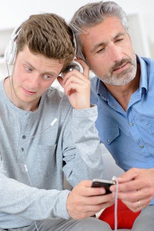 men listening to the same musicの写真素材