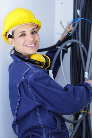 female electrician working with wire pipesの写真素材