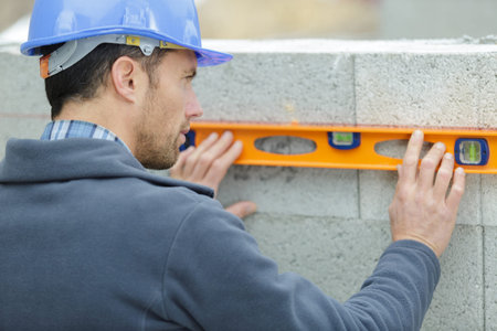 construction worker inspecting a wall