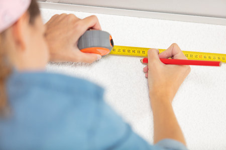 woman construction worker work with meter tape and pencil
