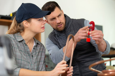 plumber and assistant butting copper pipeの写真素材