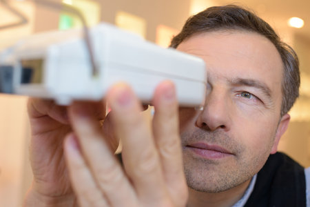 optician examines the eyesight of his pretty clientの写真素材