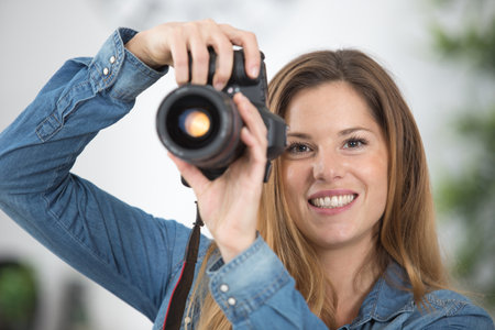 beautiful happy woman with camera at homeの写真素材