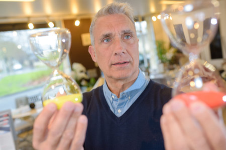 portrait of man holding two hourglass