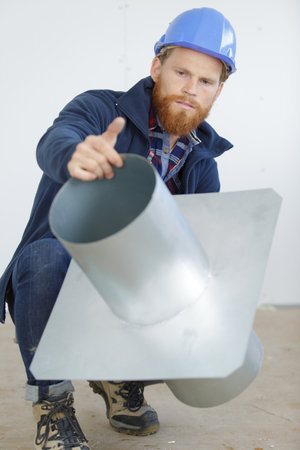 close-up of a man builder checking a metal pipeの写真素材