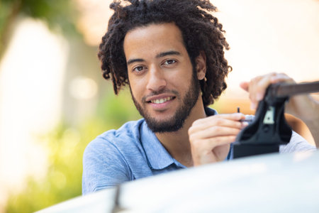 man mounts a roof rack on to his car