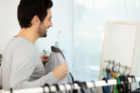 a man choosing shirt in his wardrobeの写真素材