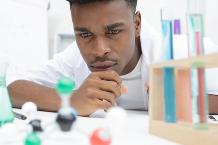 young scientist mixing reagents in glass flask in clinical laboratory