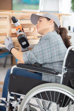 woman in wheelchair using drillの写真素材