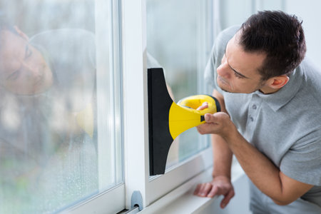 cheerful male person cleaning windowの写真素材