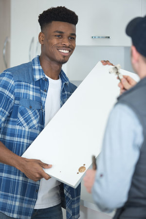 two young men installing kitchen