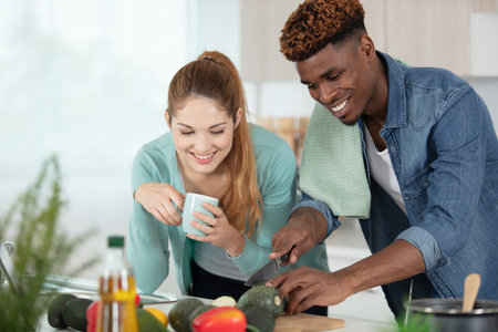loving couple cooking together in the kitchen at homeの写真素材