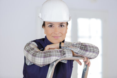 brunette woman builder in uniform looking at cameraの写真素材