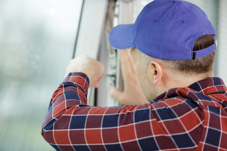 service man installing window with screwdriverの写真素材