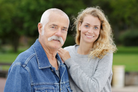 portrait of elderly man and young woman in the parkの写真素材