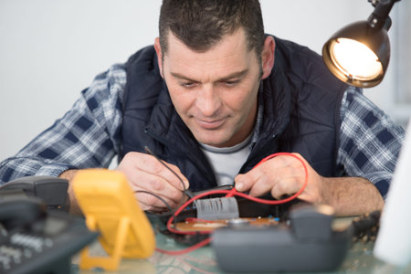 engineer using multimeter to test telephone handset