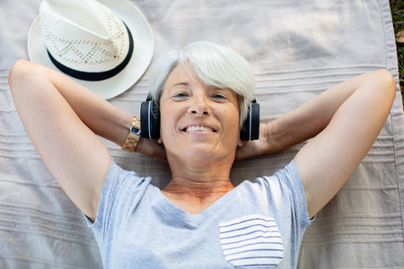 mature relaxed woman with headphone listening music