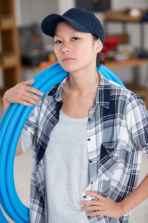 female plumber examining pipes of central heating boilerの写真素材