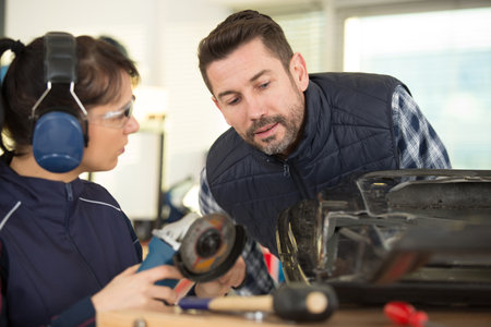 carpenter woman and man with drill in workshopの写真素材
