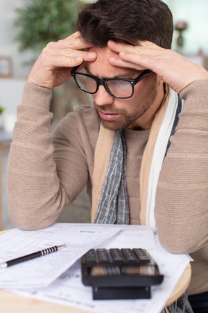 worried man looking at bills in the kitchen