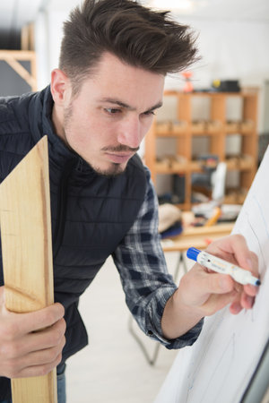 handsome young businessman writing on white boardの写真素材