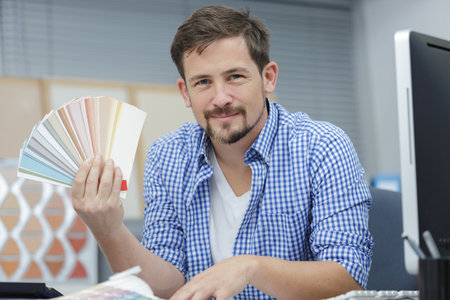 portrait of designer holding color swatch in officeの写真素材