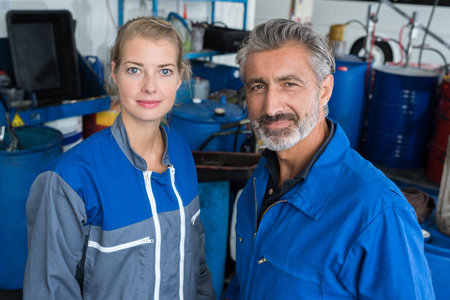 two technicians working in car serviceの写真素材