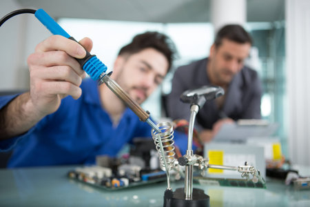close view of soldering iron being used in a workshop