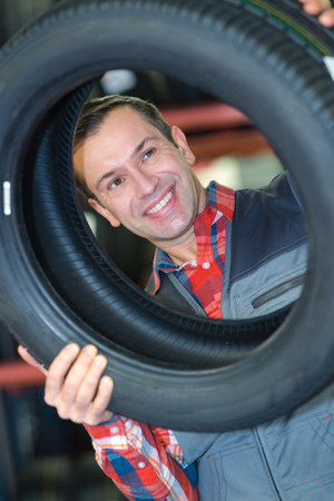 man holding rubber tire smilingの写真素材