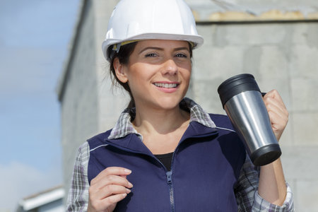 pretty female builder drinking takeaway coffeeの写真素材
