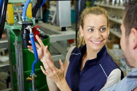 young happy woman standing among stainless equipment