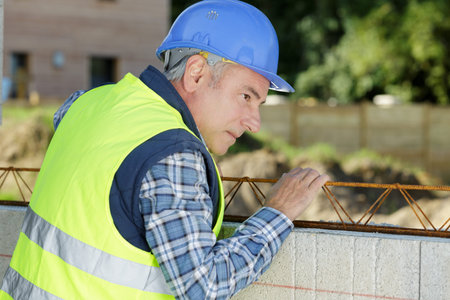 a builder measuring the outside wall