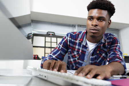 man typing on computer keyboard in office