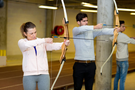 a couple practicing archery indoors