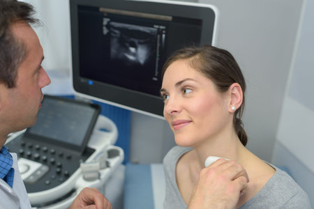 woman getting an ultrasound scan on neck by doctor