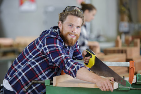 skilled craftsman cutting a wooden plankの写真素材