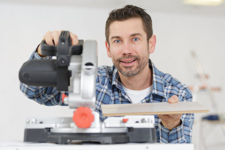 carpenter using circular saw in workshopの写真素材