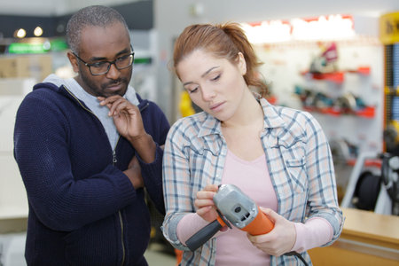 handsome man shopping for power tool in hardware store