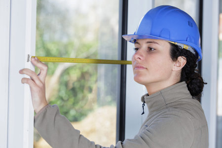beautiful young woman measuring a windowの写真素材