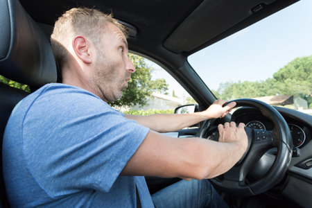 surprised male driver honking the car horn