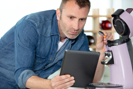 serious man repairing broken coffee machine