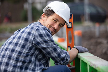 plumber checking foundation leveling using spirit level