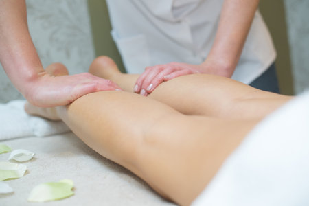 a masseuse massaging womans legsの写真素材