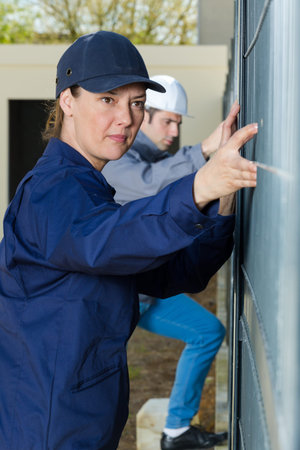 male and female builders working on wall