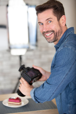 man with camera recording resh cakes and pastriesの写真素材