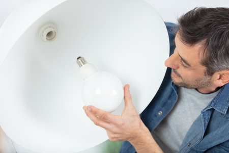 man changing light bulb at homeの写真素材