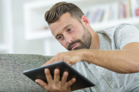 man using tablet pc at home