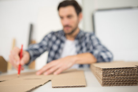 man drawing design on cardboard with a pencilの写真素材