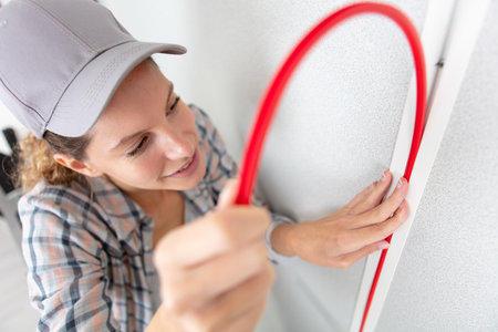 female electrician checking wiring at construction siteの写真素材